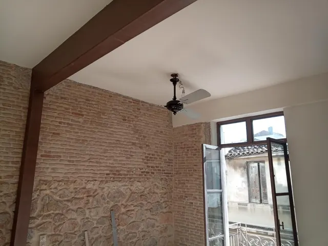 Ανεμιστήρας οροφής σε χώρο με πέτρινο τοίχο